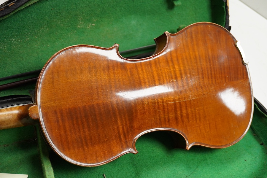 Four cased violins; an early 20th century violin, body 36cm, fitted with a microphone pick up taking a quarter inch jack plug, an early 20th century half size violin, body 32cm, and two student violins. Condition - poor